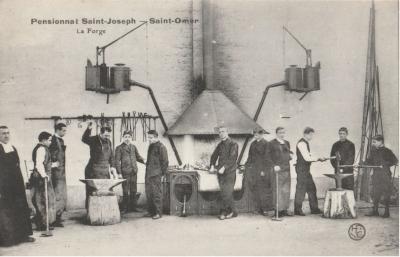 Sur la gauche, un prêtre surveille les élèves. Le professeur montre aux élèves comment se servir des outils pour forger.